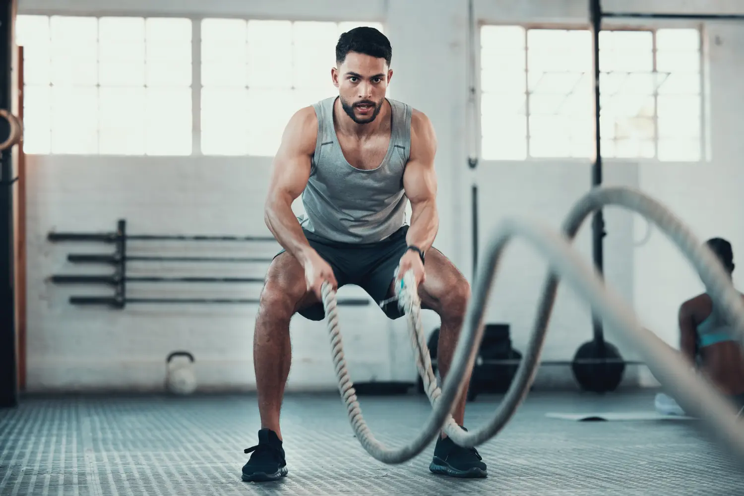 Niemals aufgeben, niemals kapitulieren. Aufnahme eines jungen Mannes, der im Fitnessstudio Seile benutzt, um seine Armkraft zu stärken.